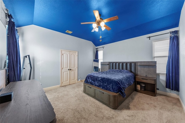 bedroom featuring light carpet, a closet, vaulted ceiling, and ceiling fan