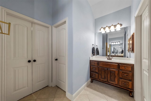 bathroom featuring tile patterned floors, vanity, and vaulted ceiling