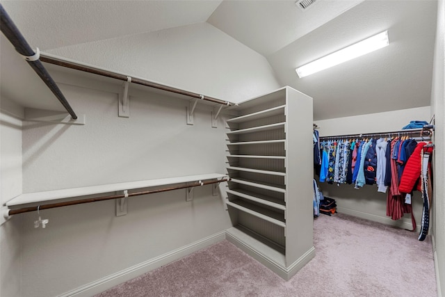 walk in closet featuring light carpet and vaulted ceiling