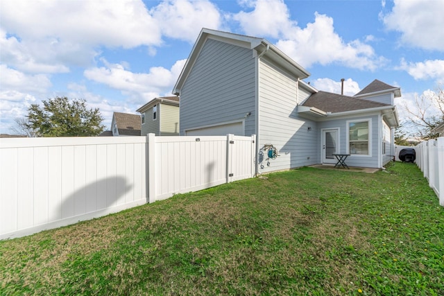 back of property with a garage and a yard