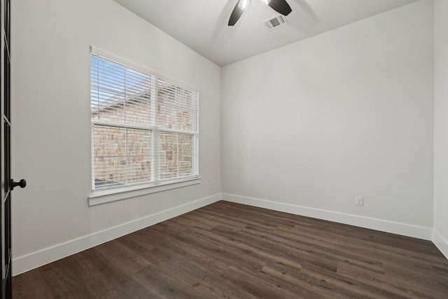 unfurnished room with a healthy amount of sunlight, dark wood-style floors, baseboards, and visible vents