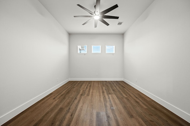 unfurnished room featuring ceiling fan, dark wood-style floors, visible vents, and baseboards