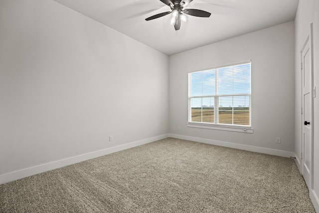 carpeted empty room with a ceiling fan and baseboards