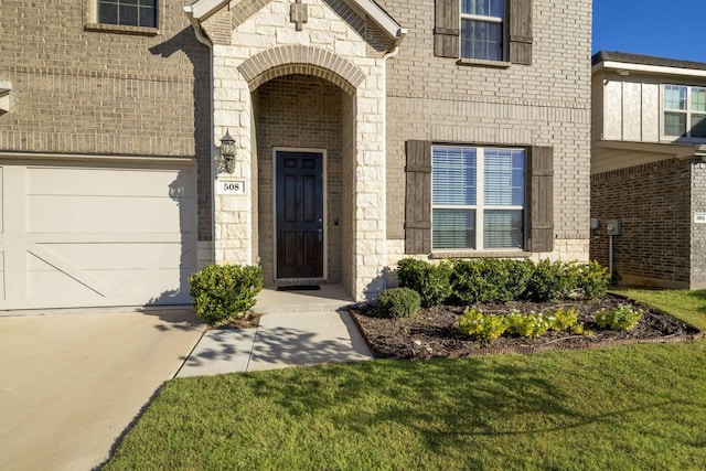 property entrance with a garage and a yard