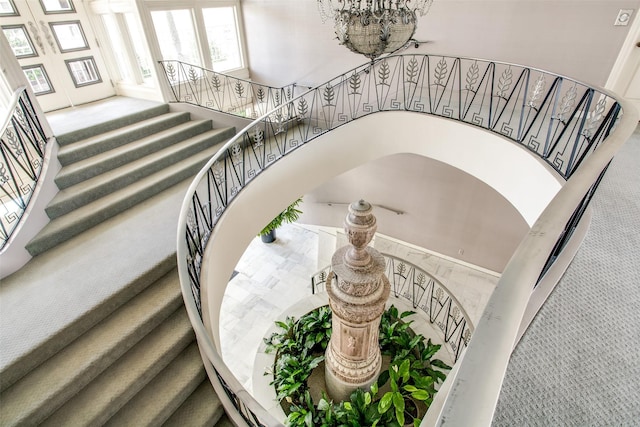 stairway featuring a towering ceiling