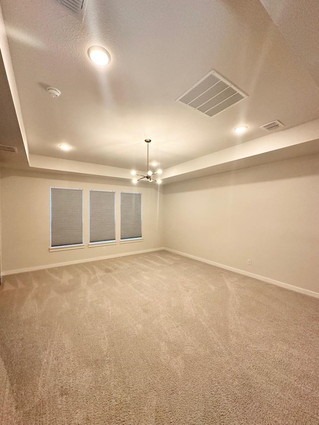 unfurnished room with carpet flooring, a chandelier, and a textured ceiling