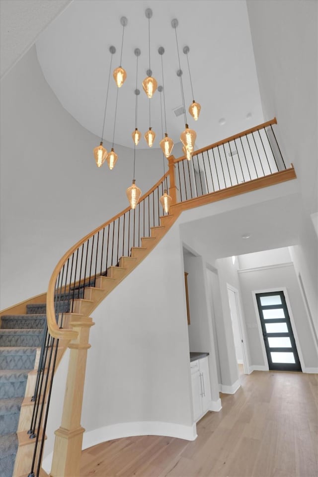 1719 Silver Marten Trl, Arlington, TX 76005 - stairs with baseboards, wood finished floors, a towering ceiling, and visible vents