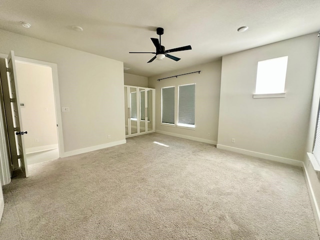 unfurnished bedroom with ceiling fan and light colored carpet