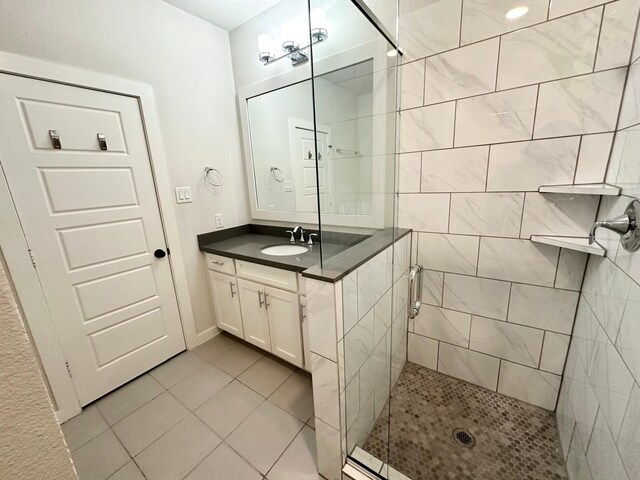 bathroom featuring tile patterned flooring, vanity, and walk in shower