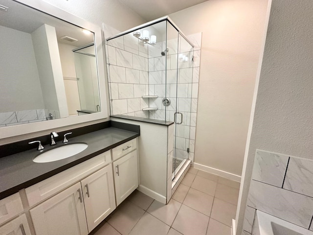 bathroom with tile patterned flooring, vanity, and an enclosed shower