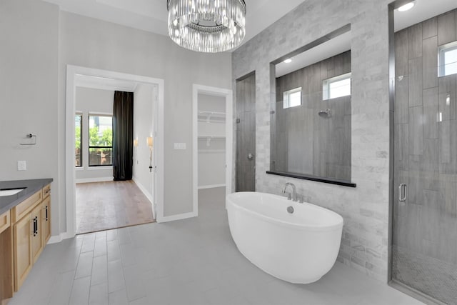1719 Silver Marten Trl, Arlington, TX 76005 - bathroom featuring a freestanding tub, vanity, a walk in closet, a stall shower, and a notable chandelier