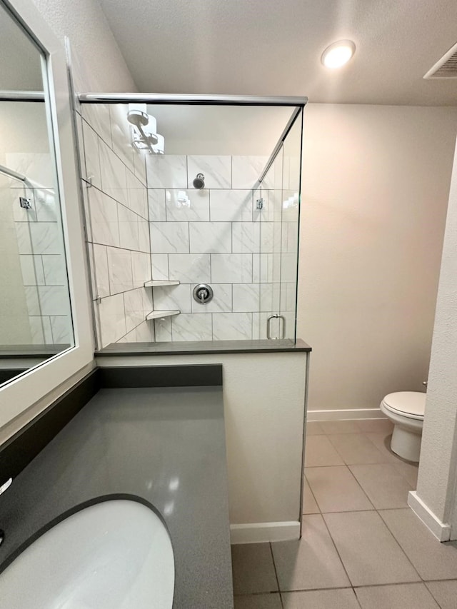 bathroom with tile patterned flooring, toilet, an enclosed shower, and sink