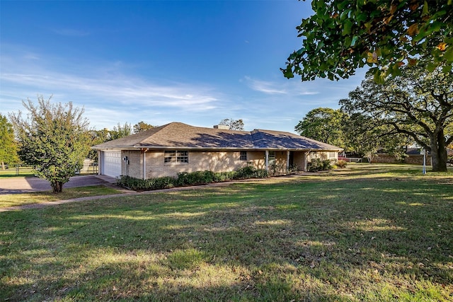 ranch-style house featuring a front yard and a garage