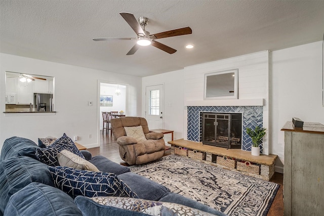 living room featuring a textured ceiling, a fireplace, and hardwood / wood-style flooring