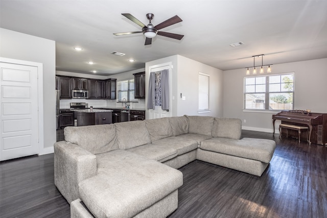 living room featuring dark wood-type flooring and ceiling fan