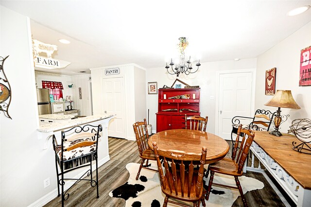 dining room with dark hardwood / wood-style floors and a notable chandelier