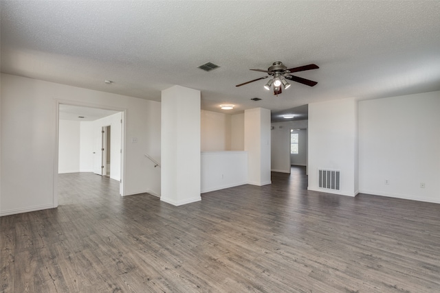 spare room featuring dark wood-type flooring, ceiling fan, and a textured ceiling