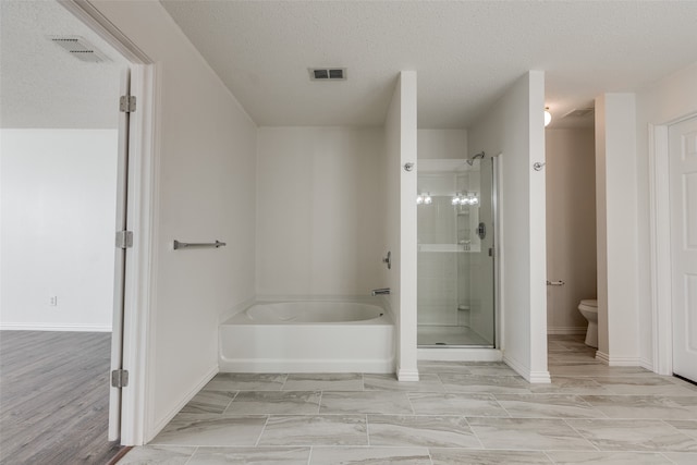 bathroom featuring shower with separate bathtub, a textured ceiling, and toilet