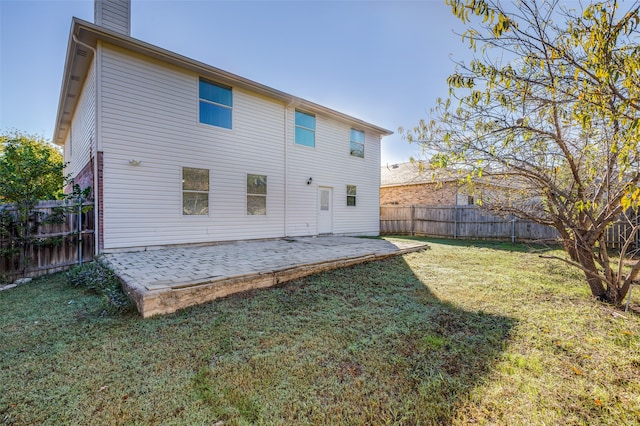 rear view of property with a lawn and a patio