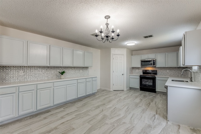 kitchen with a notable chandelier, pendant lighting, decorative backsplash, sink, and black range with electric stovetop