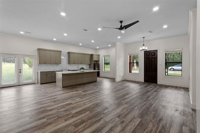 kitchen with pendant lighting, plenty of natural light, a kitchen island, and dark hardwood / wood-style flooring