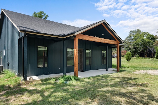 back of house with a lawn and a patio