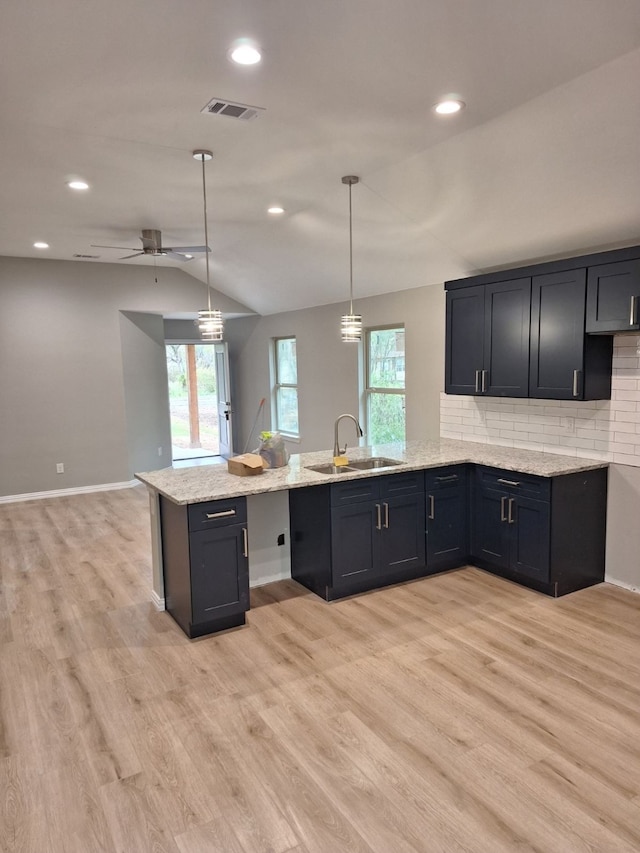 kitchen featuring hanging light fixtures, a healthy amount of sunlight, lofted ceiling, and sink