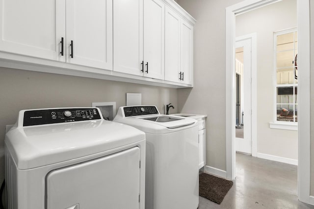 clothes washing area featuring cabinets and independent washer and dryer