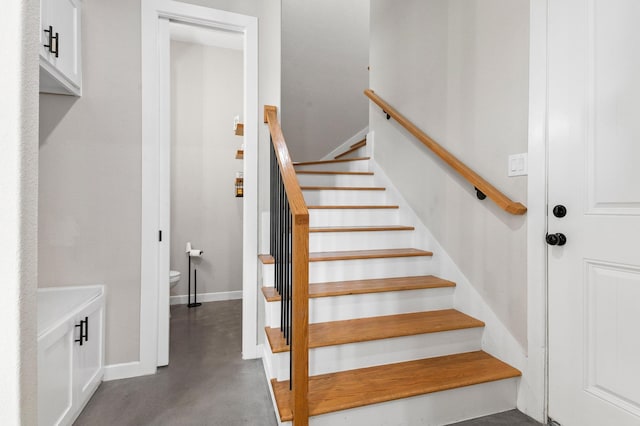 staircase featuring concrete floors