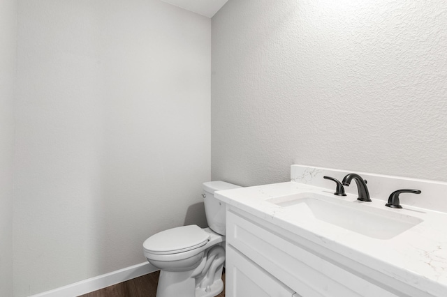 bathroom featuring hardwood / wood-style floors, vanity, and toilet