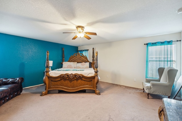 carpeted bedroom with ceiling fan and a textured ceiling