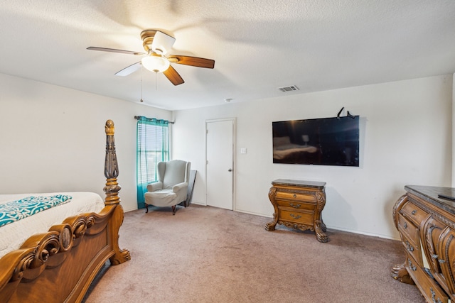 carpeted bedroom with a textured ceiling and ceiling fan