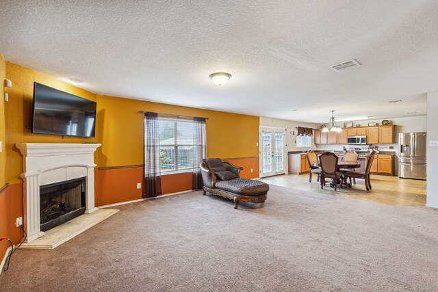 carpeted living room featuring a textured ceiling and an inviting chandelier