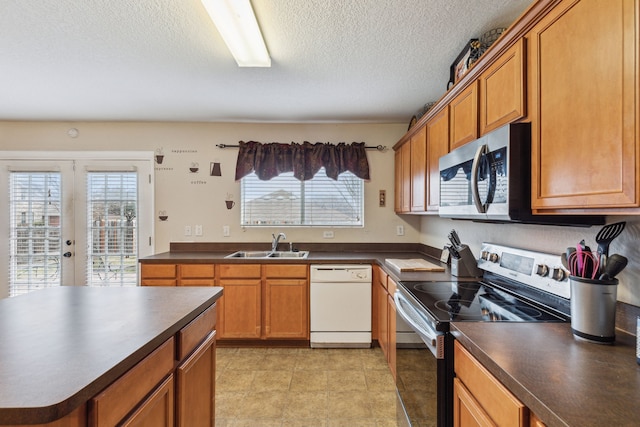 kitchen featuring sink, a textured ceiling, french doors, and stainless steel appliances