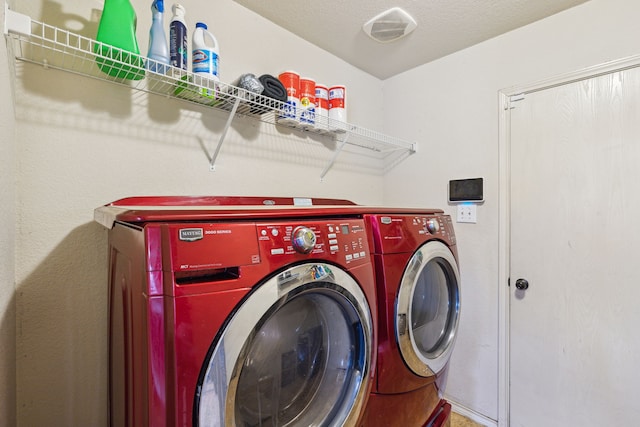 washroom with a textured ceiling and washing machine and clothes dryer