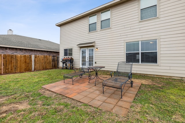 rear view of property featuring french doors, a yard, and a patio area