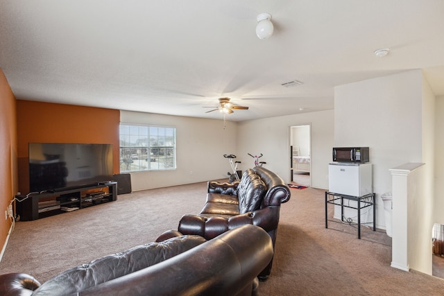 carpeted living room with ceiling fan