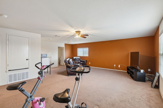 workout area featuring a textured ceiling, carpet floors, and ceiling fan