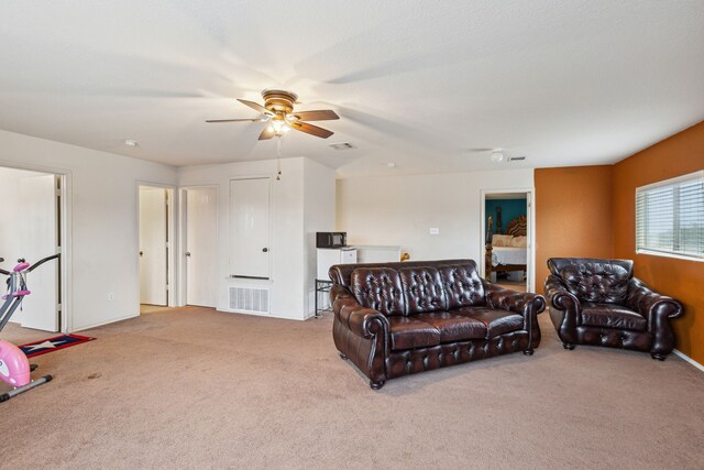 carpeted living room with ceiling fan