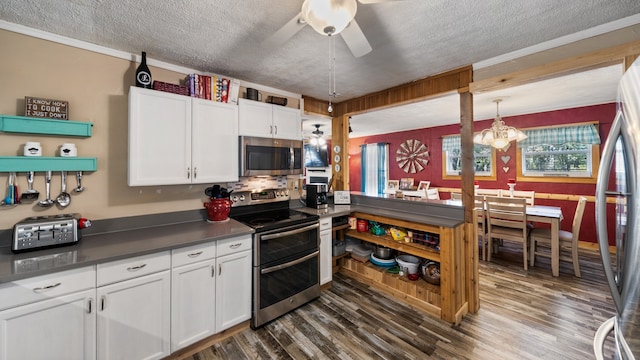 kitchen featuring a textured ceiling, white cabinetry, dark countertops, stainless steel appliances, and dark wood finished floors