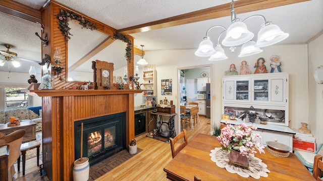 dining area featuring a textured ceiling, wood finished floors, and ceiling fan with notable chandelier
