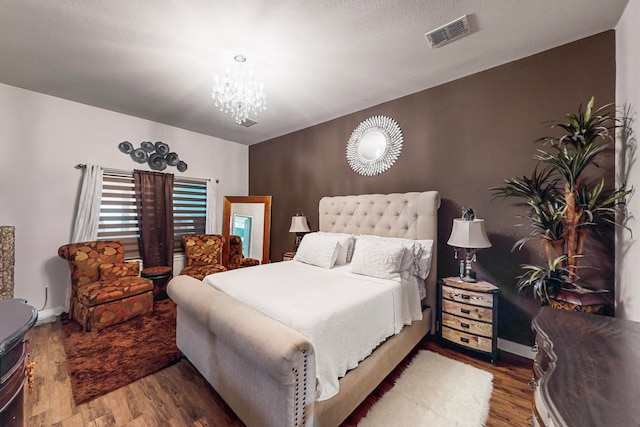 bedroom featuring hardwood / wood-style floors and a chandelier