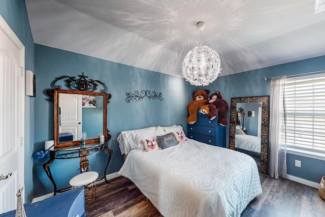 bedroom featuring vaulted ceiling, a chandelier, and dark hardwood / wood-style flooring