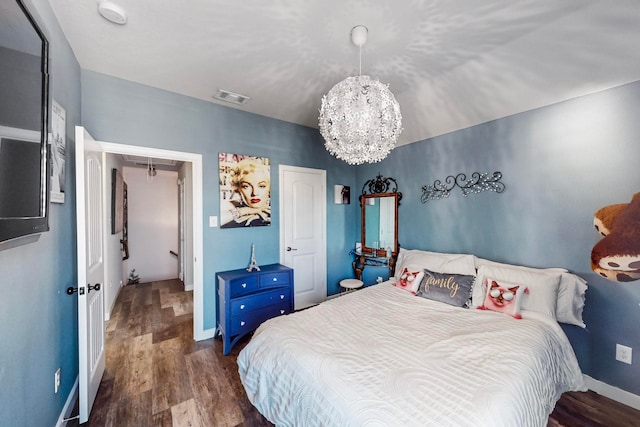 bedroom featuring dark hardwood / wood-style floors and a chandelier