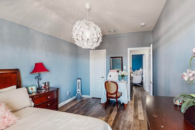 bedroom with a notable chandelier and dark hardwood / wood-style floors