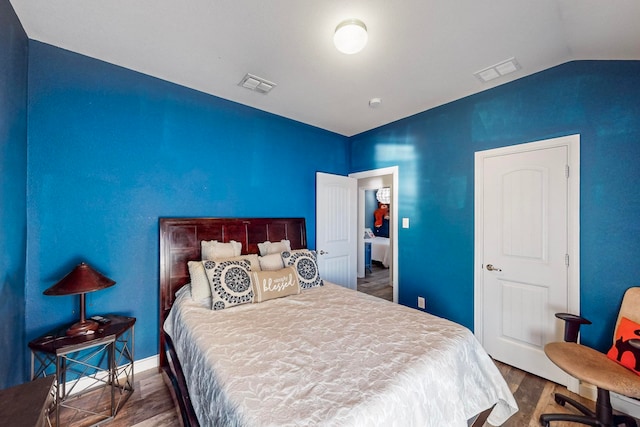 bedroom featuring dark hardwood / wood-style flooring and vaulted ceiling