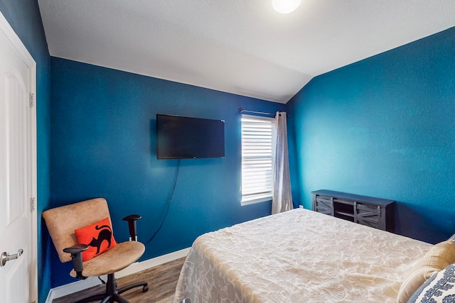 bedroom featuring hardwood / wood-style floors and lofted ceiling