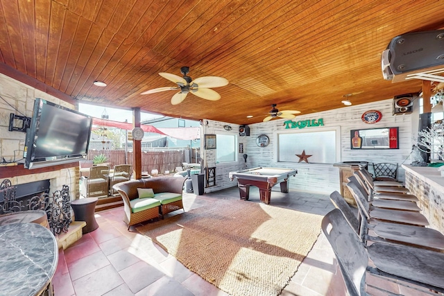 view of patio with an outdoor kitchen, ceiling fan, and an outdoor living space with a fireplace