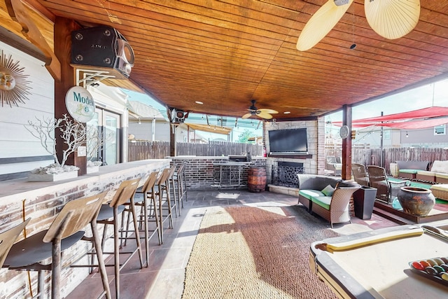 view of patio featuring ceiling fan, area for grilling, exterior bar, and an outdoor living space