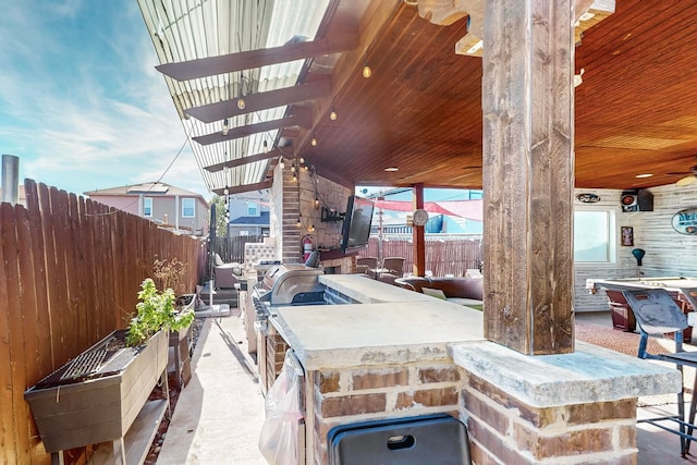 view of patio featuring exterior kitchen and an outdoor bar